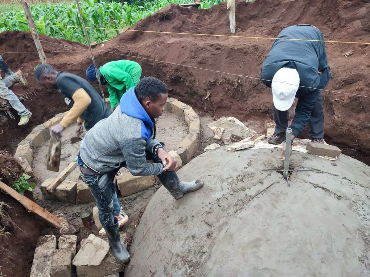 Workers plastering a digester dome